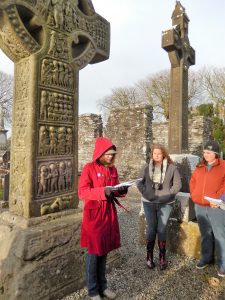 Students reading poetry near Muiredeach's Cross at Monasterboice
